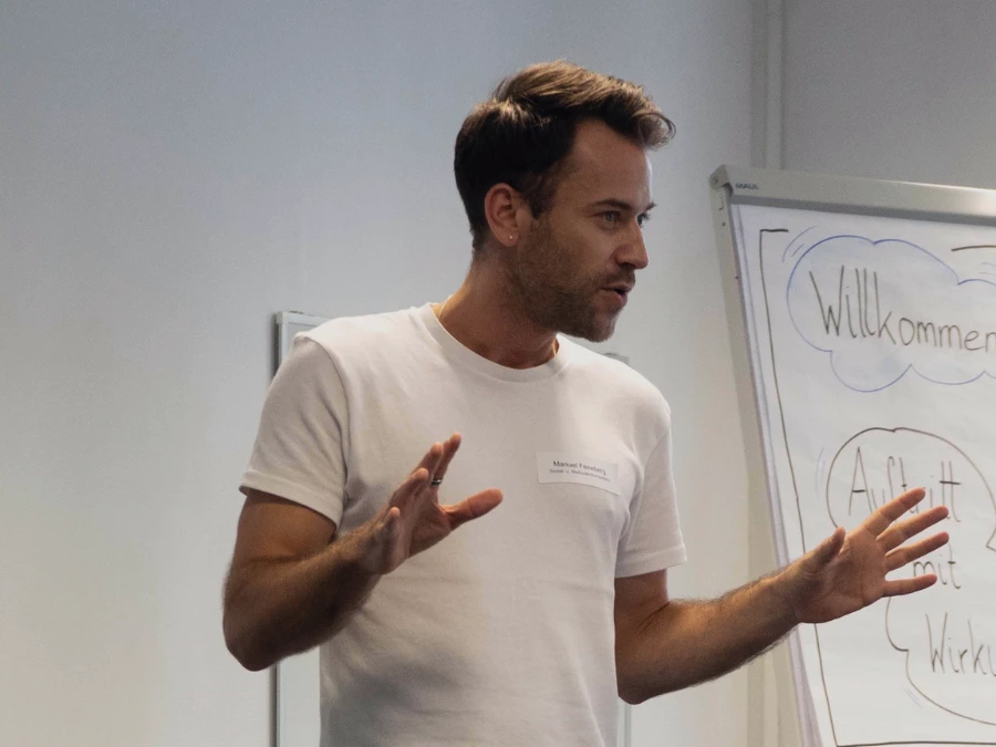 Manuel Feneberg gestikuliert vor dem Flipchart – Erscheinung und Auftritt trainieren